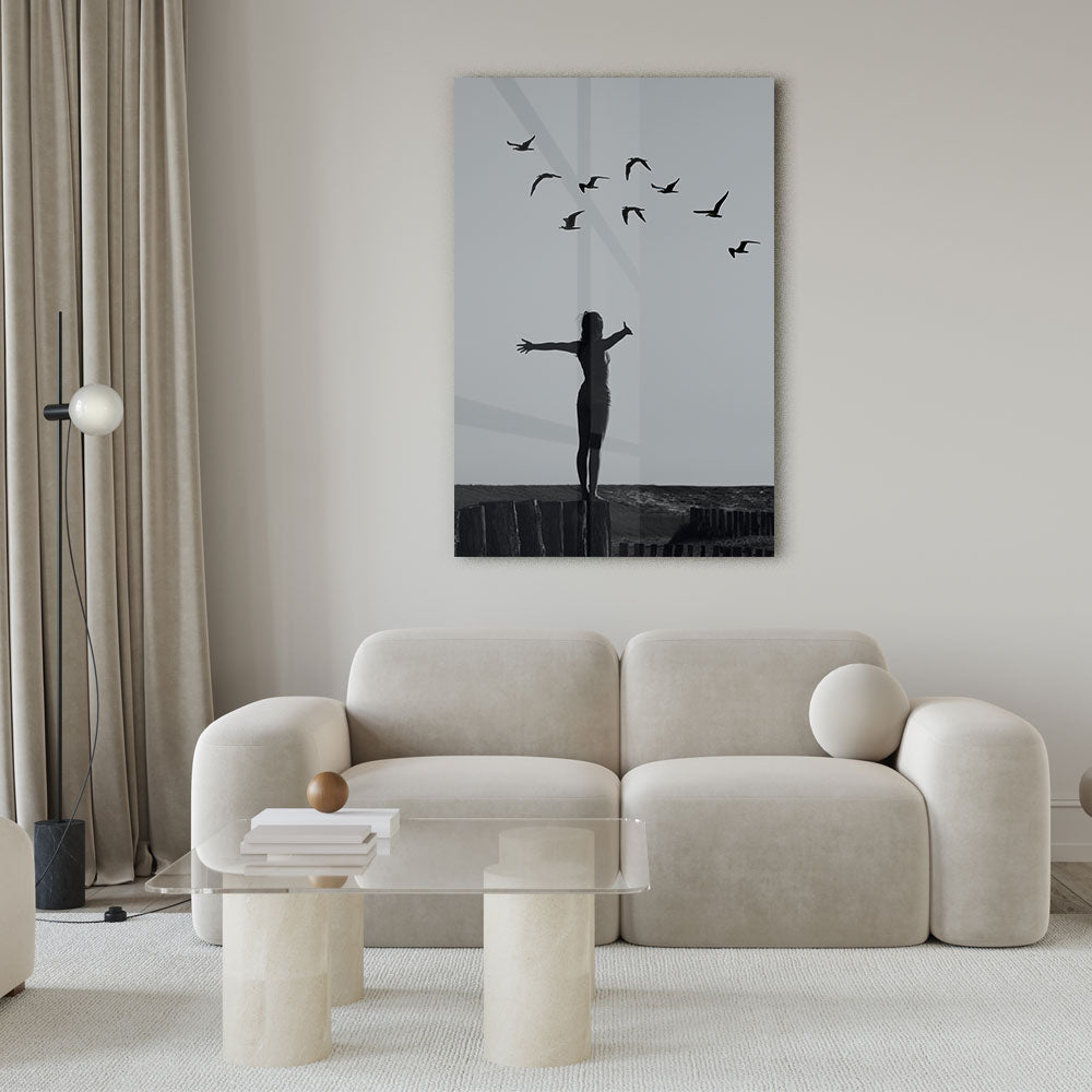 Zwart-wit fotografie van een vrouw op een rots met vogels luxe glasschilderij op groot formaat